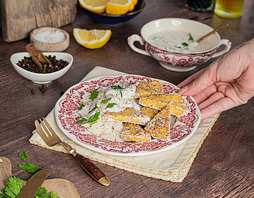 Gemüse-Dreiecke mit heller Marinade auf einem Teller mit Reis mit Tischdekoration.