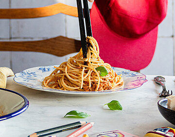 Pasta a la Bolognese Spaghetti mit Tofu-Gehacktem auf einem Teller mit Dekoration.