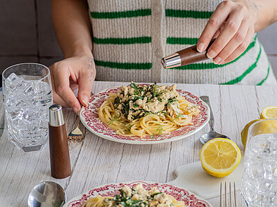 2 Teller Nudeln auf einem Teller mit Tofu-Spinat-Sauce mit Tischdekoration.