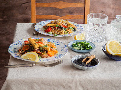 Glasnudelsalat mit buntem Gemüse und Tofustreifen auf Tellern mit Dekoration.