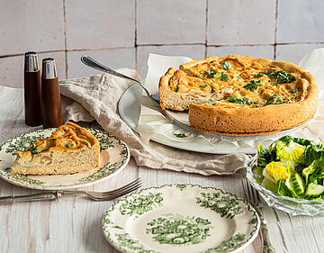 Zwiebelkuchen mit Tofu Zwiebelkuchen mit Tofu belegt, auf Tellern mit Tischdekoration.