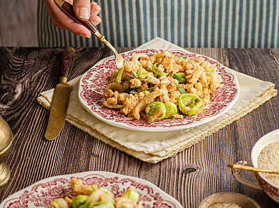 Tofu-Geschnetzeltes mit Lauch auf Tellern und geriebenem Käse.