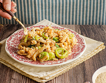 Tofu-Geschnetzeltes mit Lauch auf Tellern und geriebenem Käse.