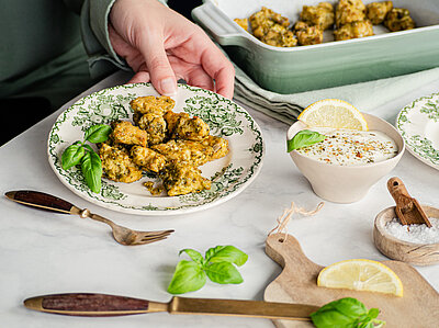 Gebackene Tofu-Würfel auf einem Teller mit Dip mit Tischdekoration.