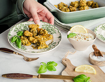Gebackene Tofu-Würfel auf einem Teller mit Dip mit Tischdekoration.