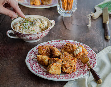 Bretzel-Nuggets mit Obazda Tofu-Bretzel-Nuggets auf einem Teller auf einem Tisch mit einer Schüssel Obazda.