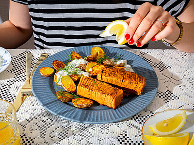 Tofustreifen mit gebackenen Kartoffeln und Dip auf einem Teller mit Dekoration.