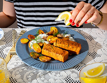 Tofustreifen mit gebackenen Kartoffeln und Dip auf einem Teller mit Dekoration.
