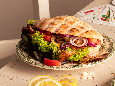 Fladenbrot auf Tellern mit Tofu, Salat und Zitronenscheiben mit Tischdekoration.