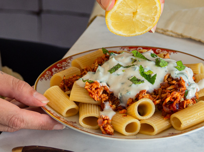 Pasta mit Tofugeschnetzeltem und Joghurt mit Zitrone und Tischdekoration.