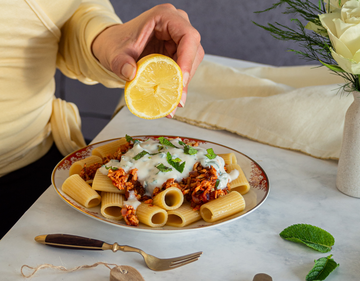 Pasta mit Tofugeschnetzeltem und Joghurt mit Zitrone und Tischdekoration.