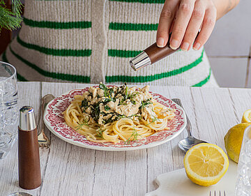 2 Teller Nudeln auf einem Teller mit Tofu-Spinat-Sauce mit Tischdekoration.