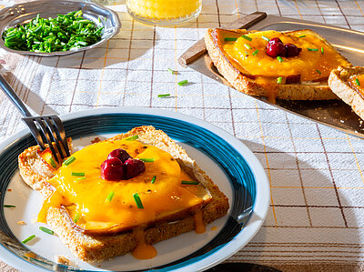 Scheiben Toast, jeweil mit einer Scheibe Tofu, Ananas, Käse und Kirschen belegt mit Tischdekoration.