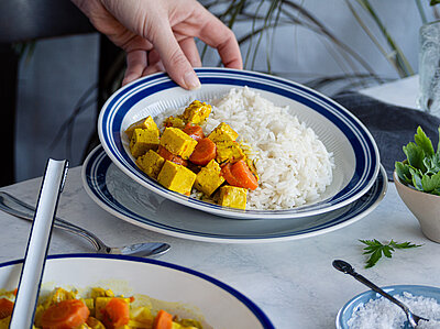 Tofu und Gemüse mit Reis auf Teller.