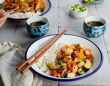 Tofu mit Gemüse und Reis auf Teller mit Dip.