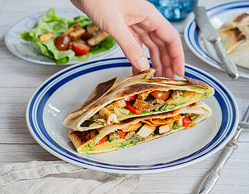 Wraps mit Tofu und buntem Gemüse auf einem Teller mit Dekoration.