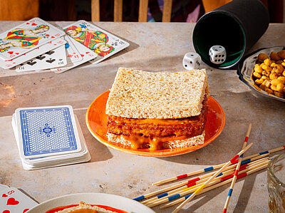 Sandwich mit Tofu und roter Sauce auf einem Teller mit Tischdekoration.